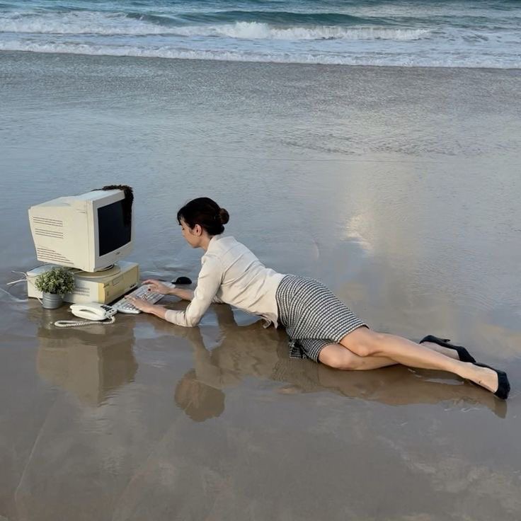 Jobber på datamaskin på stranden